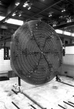 [Photo of the cyclotron vacuum tank being lowered onto the magnet.]